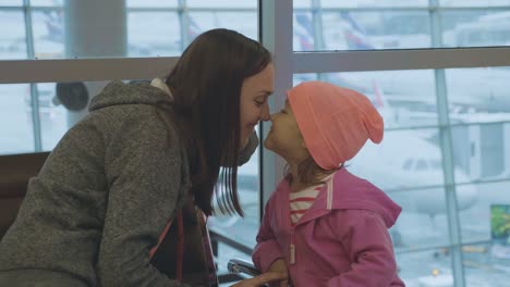 Jungen-Mutter-und-kleine-niedliche-Tochter,-die-Spaß-am-Flughafen-in-Zeitlupe.