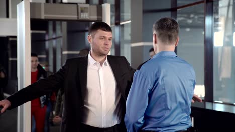 Businessman-passing-border-control-with-metal-detector