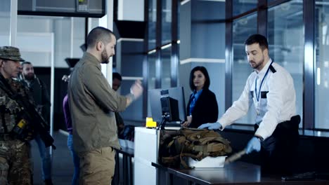 Arma-de-tránsito-del-hombre-de-pie-en-el-aeropuerto