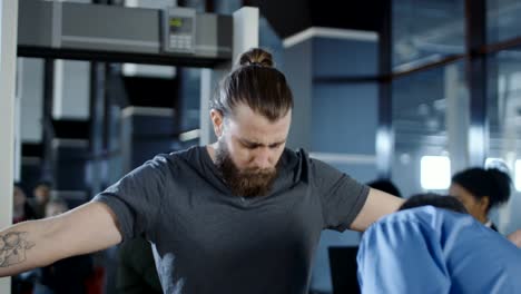 Airport-worker-checking-passenger-with-metal-detector