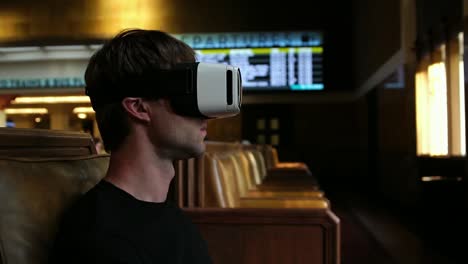 Young-tourist-man-using-VR-headset-for-travel-entertainment-at-the-airport