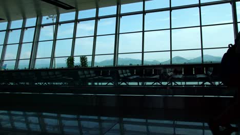 Silhouette-of-businessman-passengers-walking-in-the-busy-airport-building