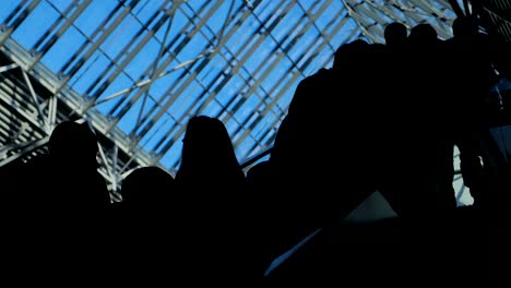 The-glass-window-airport-ecsalator-with-moving-silhouette-of-people