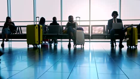 Multi-ethnic-crowd-of-people-at-airport-gate-waiting-room