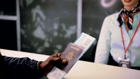 Man-taking-passport-and-boarding-pass-from-airport-check-in-desk