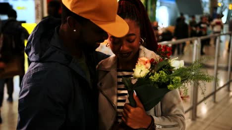 Young-emotional-couple-embracing-at-airport-after-flight-arrival