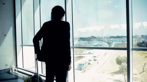 Junger-Geschäftsmann-Überprüfen-der-Zeit-und-den-Flughafen-Fenster-Ausblick