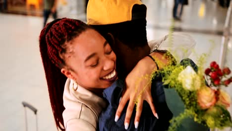 Young-people-meeting-and-embracing-at-airport-after-flight