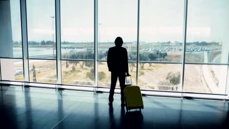 Junger-Geschäftsmann-im-Anzug-suchen-Flughafen-Fenster