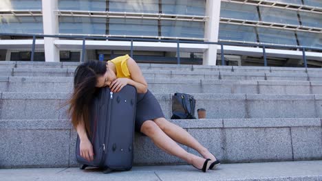 Mujer-de-negocios-asiáticos-durmiendo-en-maleta-al-aire-libre