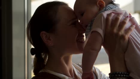 Loving-mother-carrying-little-girl-while-waiting-at-airport