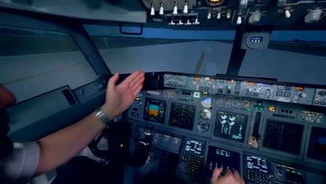 Ein-Flugzeug-geht-auf-eine-Piste,-zwei-Piloten-in-einem-Flug-Simulator-Cockpit.