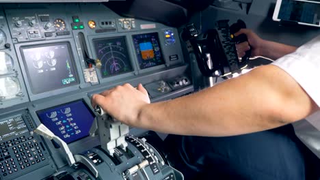 A-pilot-switches-a-lever-and-steers,-close-up.