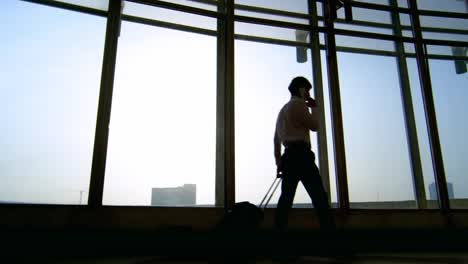 Businessman-with-Suitcase-Walking-and-Talking-on-Phone