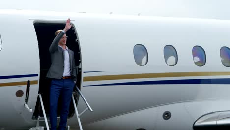 Businessman-waving-at-the-entrance-of-private-jet-4k