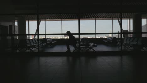 Silhouette-der-Passagier-sitzt-in-einem-Flughafen,-Sitzecke