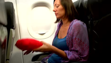 A-woman-in-a-plane-puts-a-pillow-under-her-head