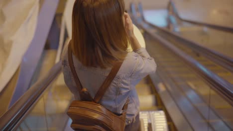 Gerne-Asiatin-mit-Wagen-oder-Karren-mit-viel-Gepäck-zu-Fuß-in-terminal-Halle-beim-boarding-Flug-am-Abfluggate-im-Flughafen-gehen.-Frauen-glücklich-in-das-Flughafenkonzept.