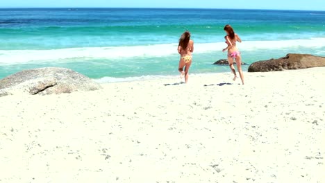 Two-women-playing-with-a-football-and-running