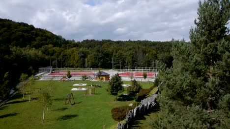 Flight-over-a-children's-playground,-basketball-and-football-court