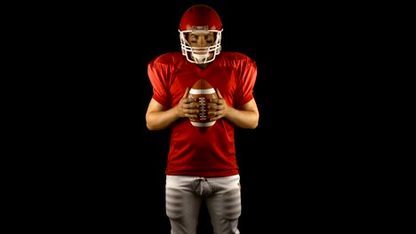 Red-american-football-player-holding-a-ball