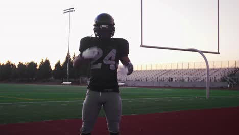 Portrait-of-a-football-player-putting-on-his-helmet