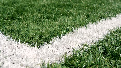 Close-up-of-the-out-of-bounds-line-on-a-turf-football-field