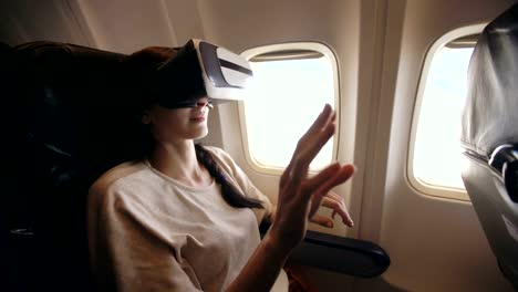 Mujer-joven-turista-relajarse-y-utilizar-auricular-VR-para-smartphone-durante-el-vuelo-en-avión