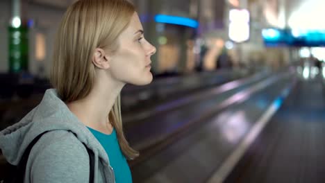 Beautiful-attractive-woman-in-airport-terminal.-Waiting-for-flight.-Using-travolator,-looking-around