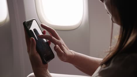 Detalle-de-mujer-con-celular-en-avión
