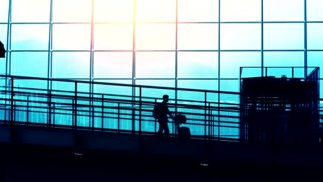 Sonnenuntergang-Silhouetten-der-Pendler-im-Flughafen.