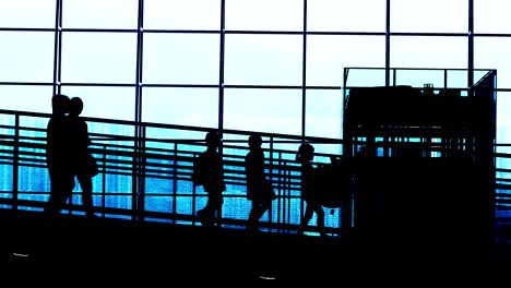 Sonnenuntergang-Silhouetten-der-Pendler-im-Flughafen.