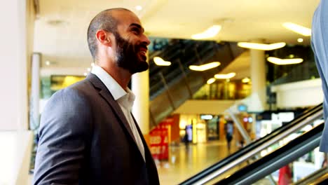 Business-people-interacting-on-an-escalator