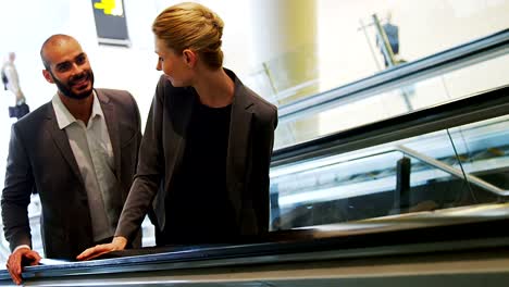 Business-people-interacting-on-an-escalator