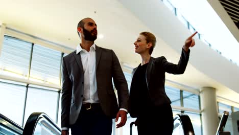 Business-people-interacting-on-an-escalator