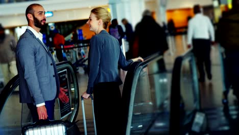 Business-people-interacting-on-an-escalator