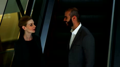 Business-people-interacting-on-an-escalator