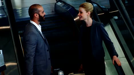 Business-people-interacting-on-an-escalator