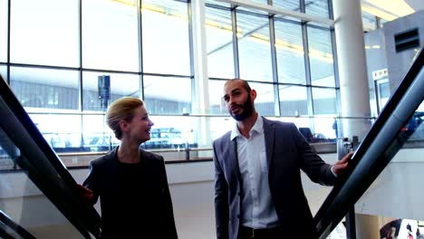 Business-people-interacting-on-an-escalator