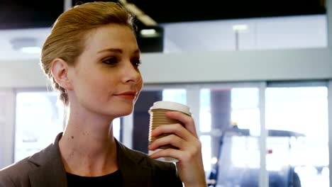 Businesswoman-having-coffee-from-disposable-cup