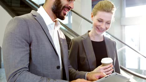 Business-people-discussing-over-digital-tablet