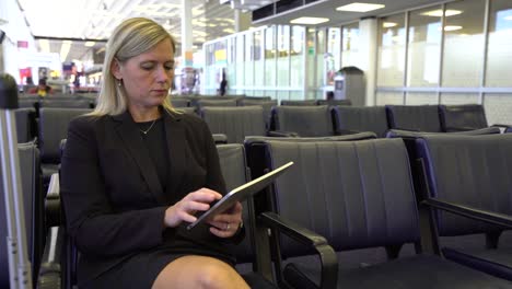 Mujer-de-negocios-usando-tableta-digital-en-el-aeropuerto