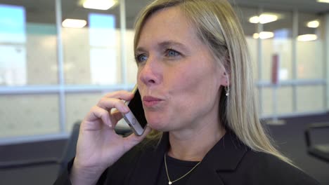 Business-woman-talking-on-cell-phone-at-airport