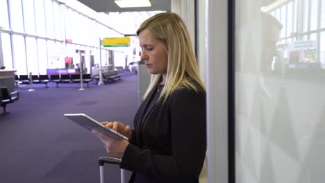 Mujer-de-negocios-usando-tableta-digital-en-el-aeropuerto