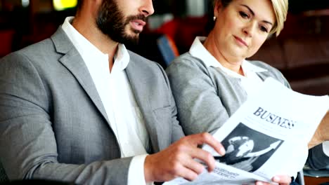 Empresario-sosteniendo-el-periódico-e-interactuando-con-mujer