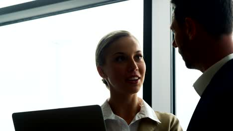 Businessman-and-woman-discussing-on-laptop