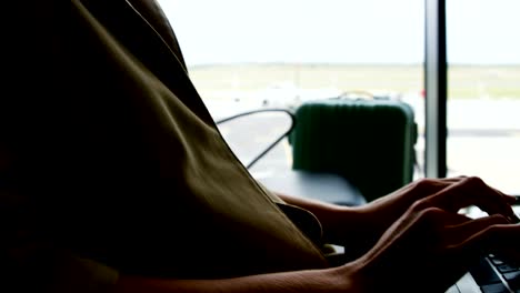 Businesswoman-using-laptop-at-airport