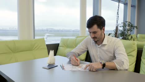 Businessman-paints-coloring-book-in-airport-during-waiting-boarding-on-plane