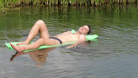 Resting-The-Man-In-The-Hot-Summer-Day-Swimming-In-The-River-On-The-Mattress.