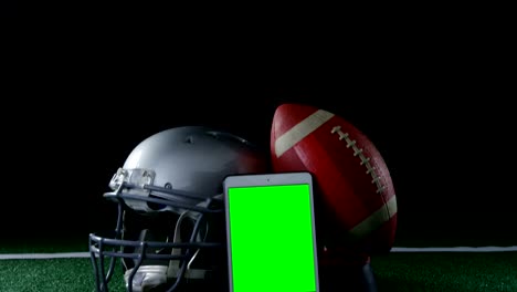 Close-up-of-football,-mobile-phone-and-head-gear-on-artificial-turf-4k